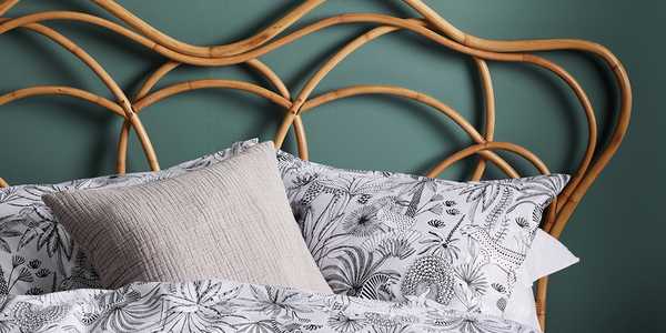 Patterned pillowcases on wooden bed.
